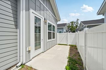 A grey house with a white fence 